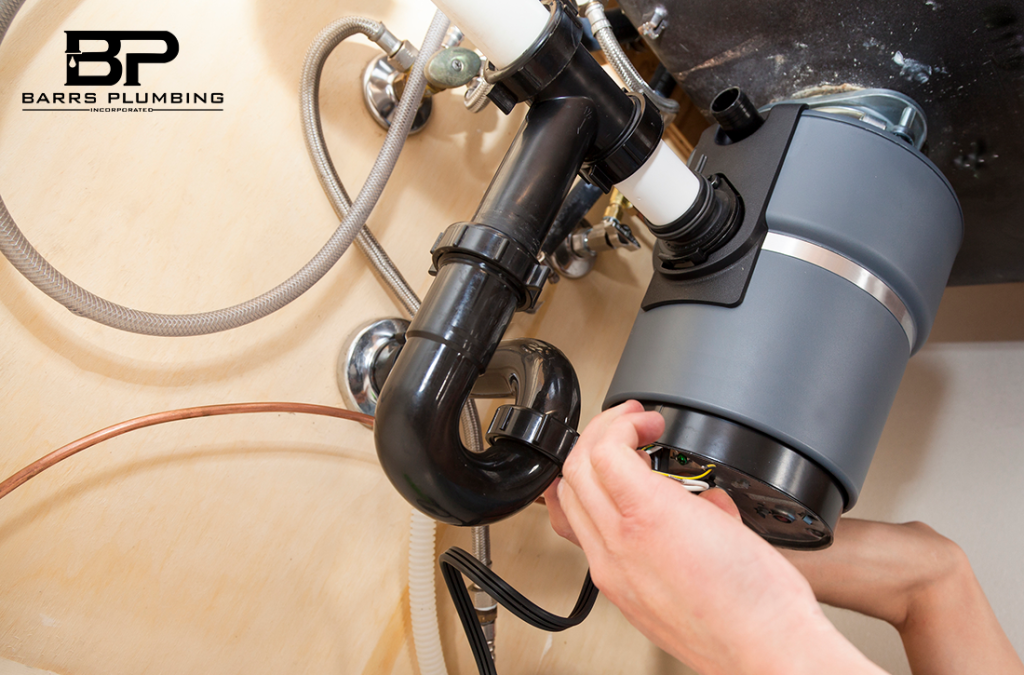 Man installing garbage disposal in home.