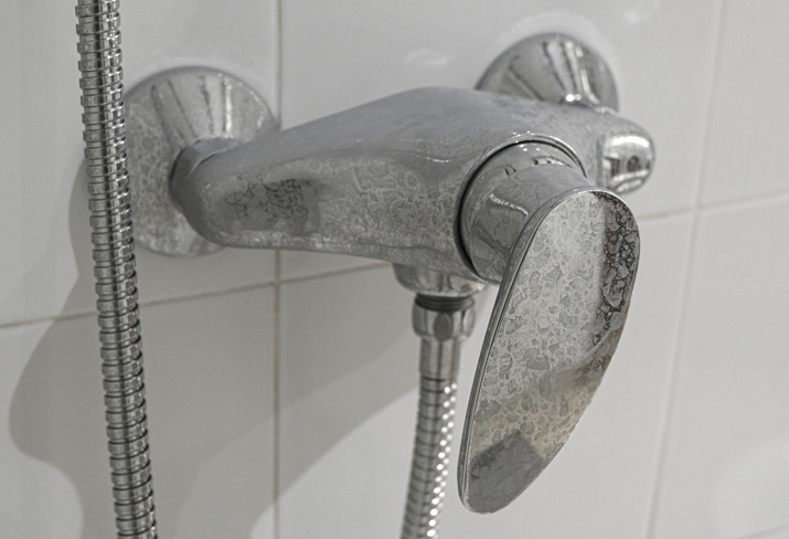 Close-up of a calcified faucet in the shower